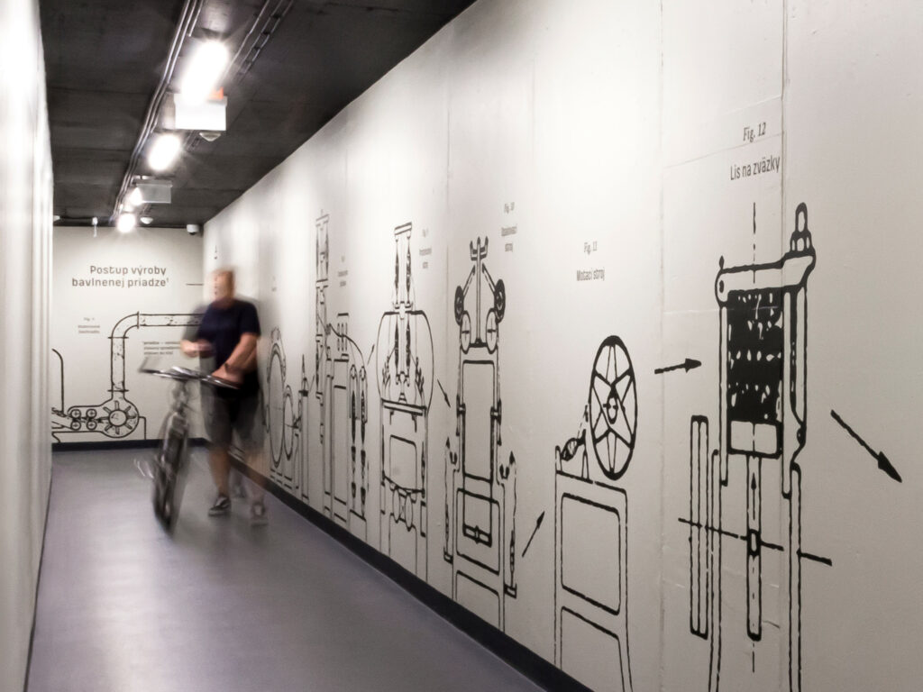 Pohľad na ilustrácie výrobných strojov, prechod do garáže objektu Pradiareň 1900